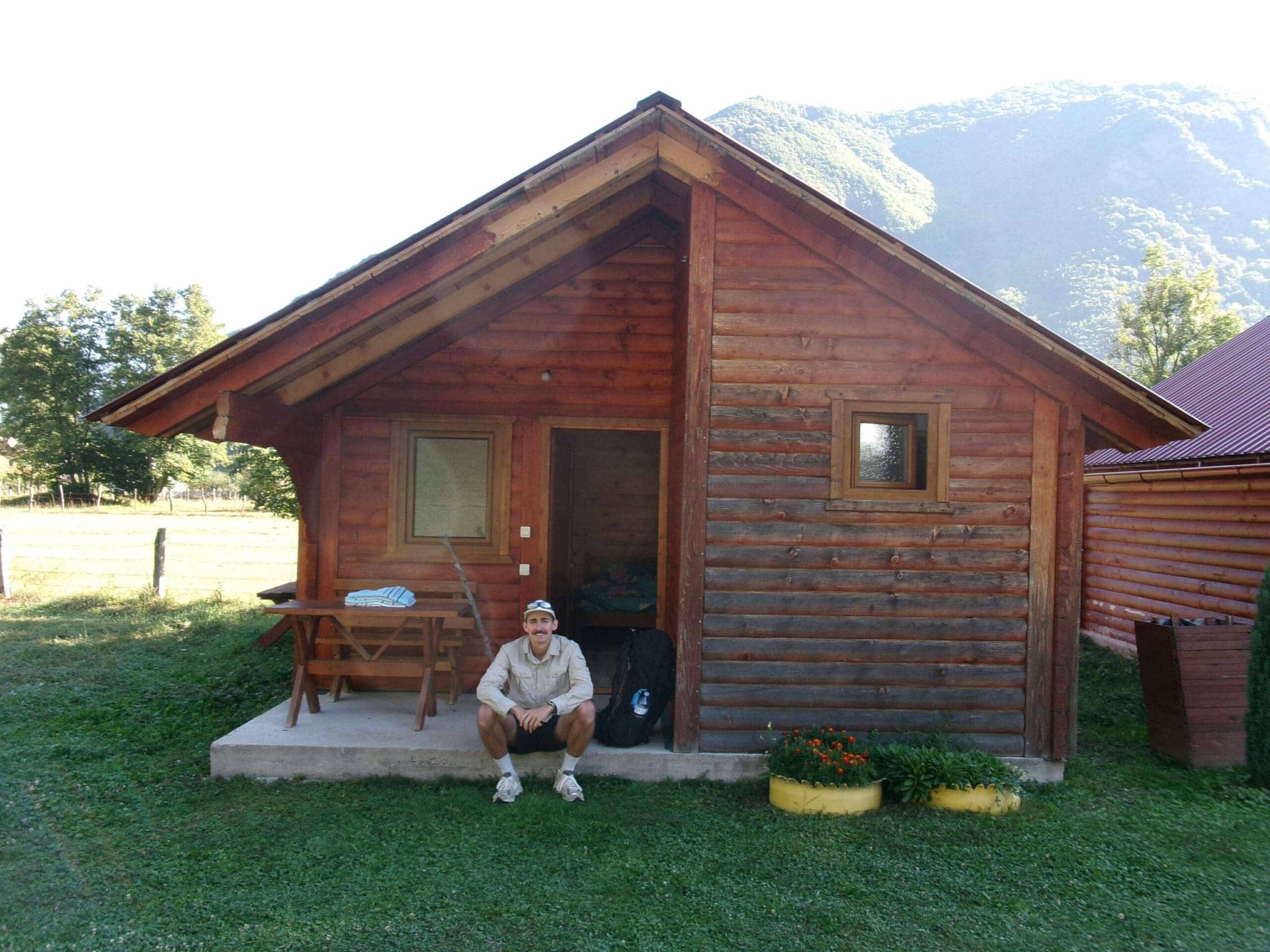Riley sitting in front of a cabin in Vusanje