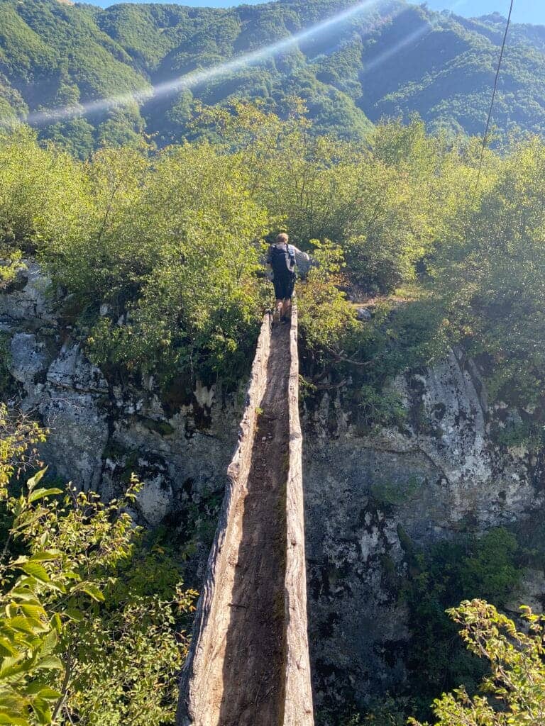 Brian crossing a log bridge, heading towards Theth