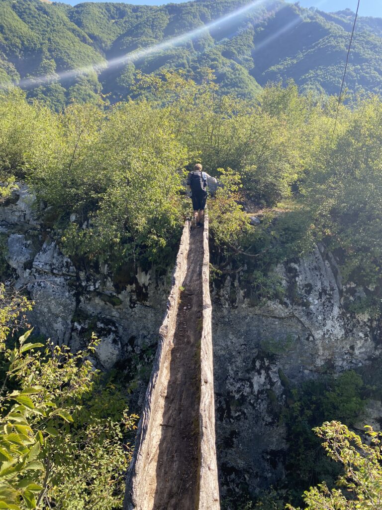 Brian crossing a log bridge, heading towards Theth