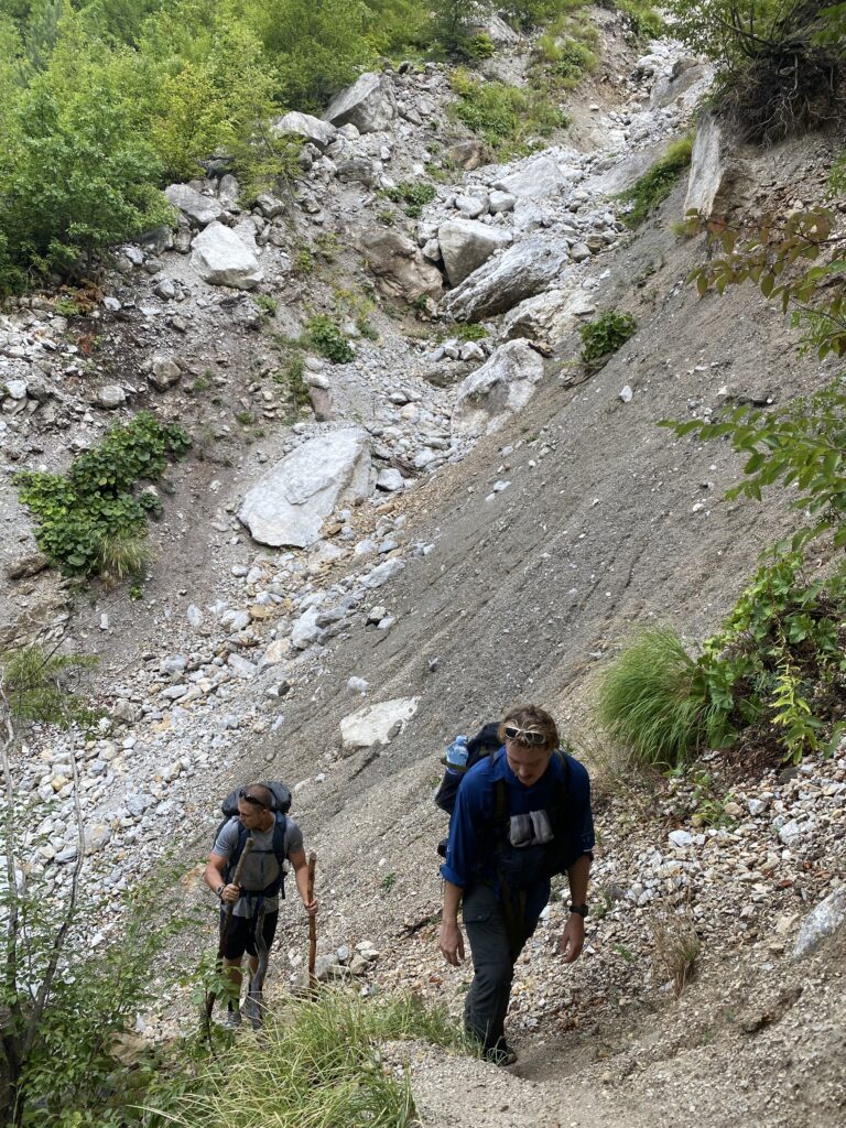 Gummy and Brian hiking alongside a recent landslide