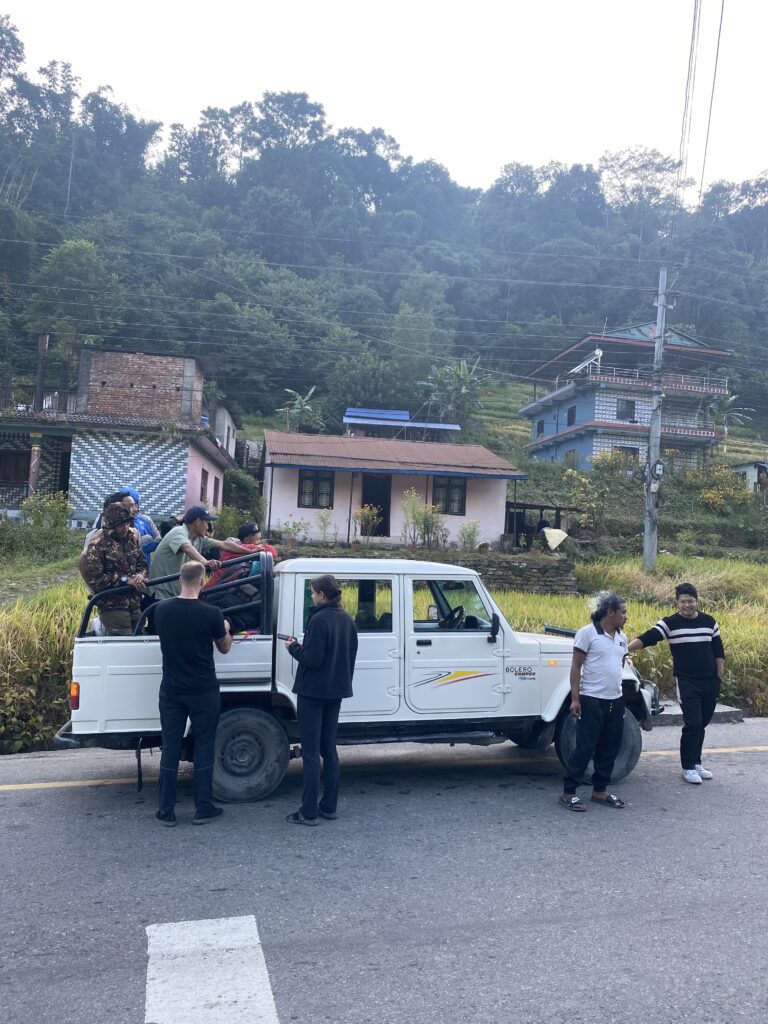 Hikers standing around a jeep bound for Chame in the Himalayas
